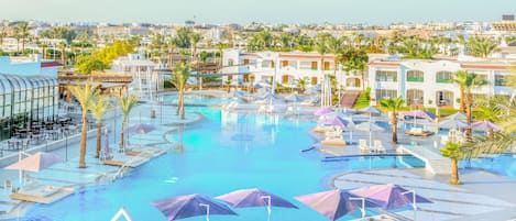 A resort with multiple swimming pools, sun loungers, and umbrellas.