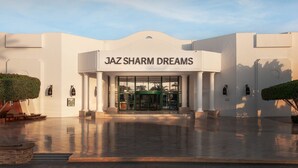 Um edifício com uma placa que diz 'JAZ SHARM DREAMS' e entrada de vidro.