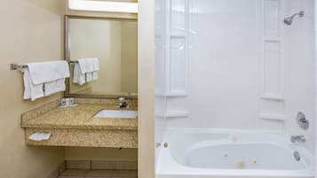 Une salle de bain avec un lavabo, un miroir et une baignoire.