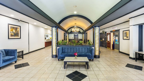 A lobby with a blue sofa, a coffee table, and a reception desk. - Comfort Inn & Suites Edmonton Downtown (Edmonton)