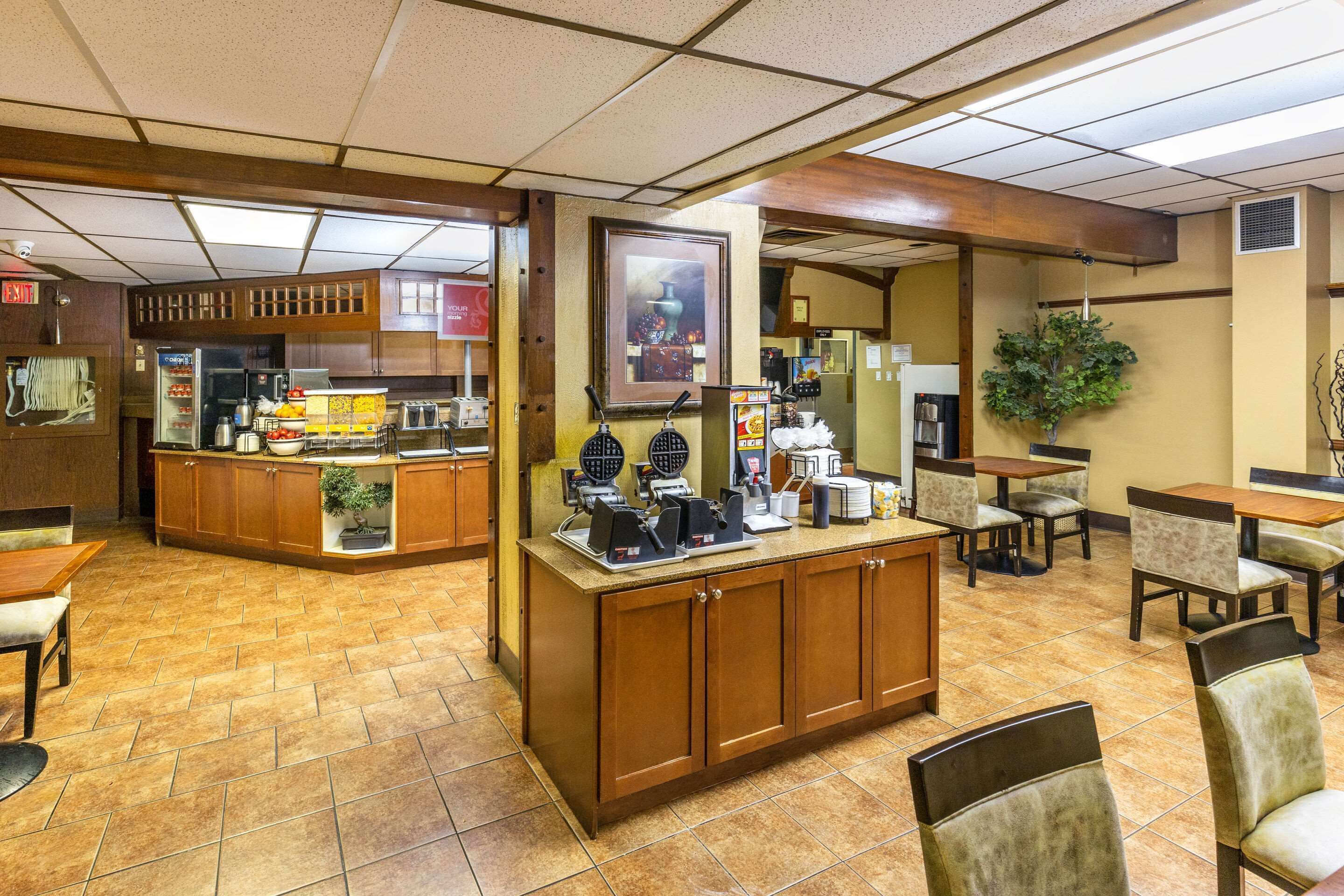 A restaurant with a counter, seating area, and a kitchen in the background.