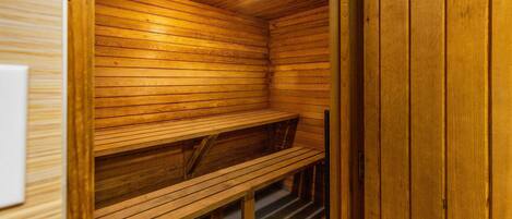 Eine Holzsauna mit Bänken und einer Deckenleuchte.