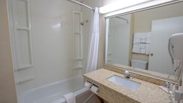 Un baño con bañera, lavamanos, espejo y perchero para toallas.