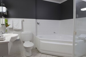 Une salle de bain moderne avec un lavabo, des toilettes et une baignoire, le tout de couleur blanche.
