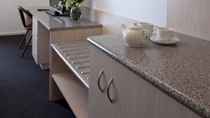 Une cuisine moderne avec des meubles en bois, un plan de travail en granit et un petit coin repas.