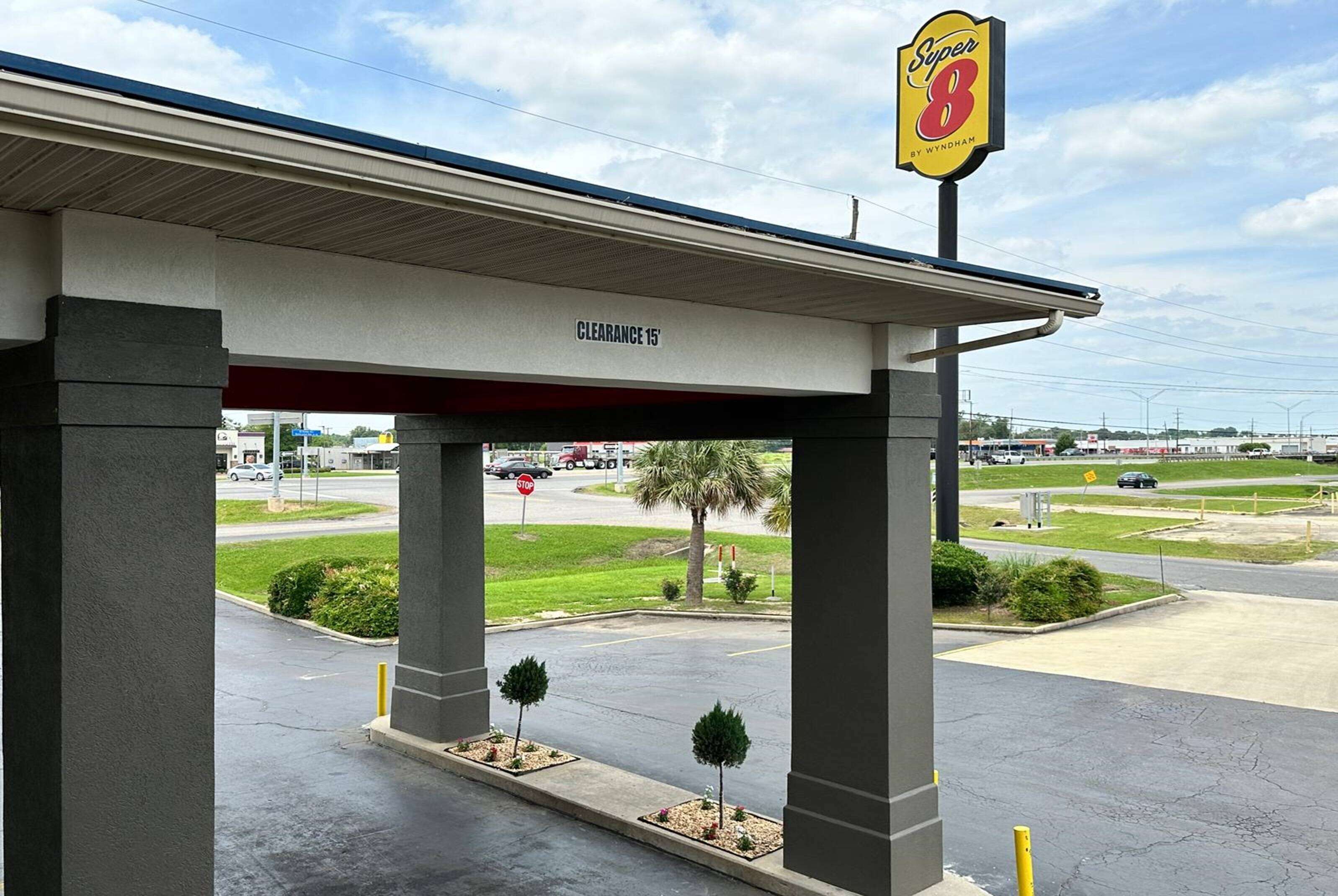 A gas station with a 'Super 8' sign, a 'Clearance 15' sign, and a stop sign in the background.