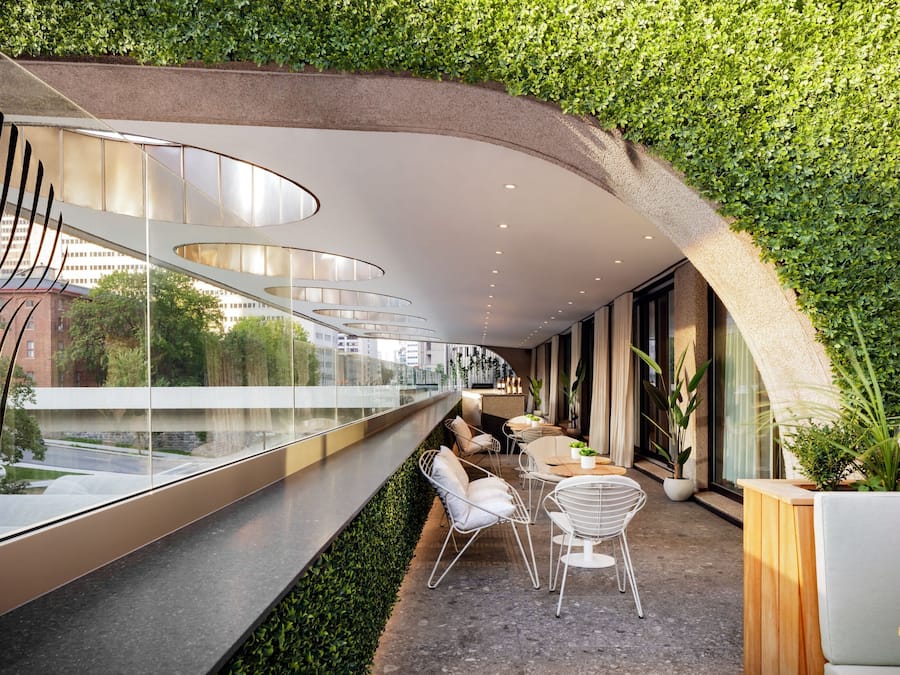 Un interior moderno con techo curvo, zona de estar y vista panorámica de la ciudad.
