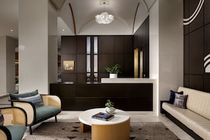 A modern lobby with a reception desk, seating area, and a decorative plant centerpiece. - Montreal Marriott Chateau Champlain (Montreal)