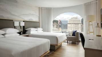 A hotel room with two beds, a desk, a chair, and a large window with a city view.