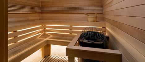 Una sauna con bancos de madera y calentador.