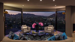 A modern living room with a large panoramic window, a round coffee table, two armchairs, and a vase with flowers. - Sanctuary Camelback Mountain Resort and Spa (Paradise Valley)