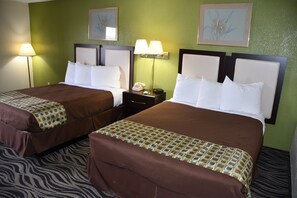 Habitación de hotel con dos camas, paredes verdes y alfombra estampada de cebra.