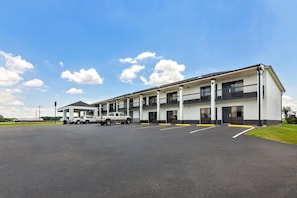 A multi-story hotel with a covered parking area and a white exterior. - Americas Best Value Inn Bishopville (Bishopville)