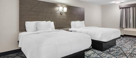 A hotel room with two beds, a large wall-mounted light fixture, and a patterned carpet.