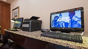 A home office setup with a desktop computer, a printer, and a keyboard on a granite countertop. - Best Western Plus Brunswick Bath (Brunswick)