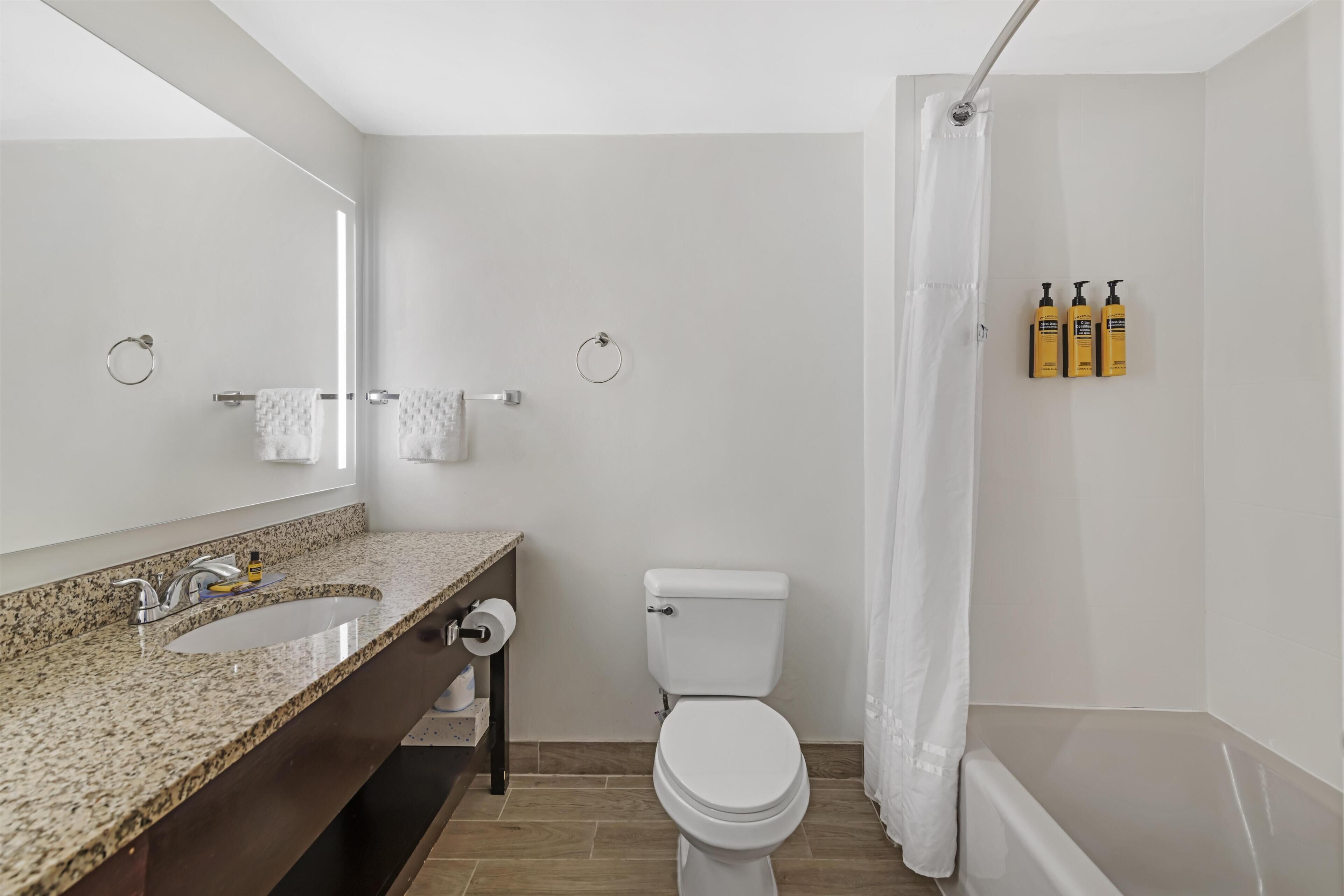 A bathroom with a sink, toilet, and shower curtain.