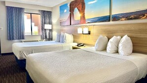 A hotel room with two beds, a nightstand, a lamp, and a painting of a landscape. - Days Inn by Wyndham Rio Rancho (Rio Rancho)