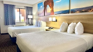 A hotel room with two beds, a nightstand, a lamp, and a painting of a landscape. - Days Inn by Wyndham Rio Rancho (Rio Rancho)