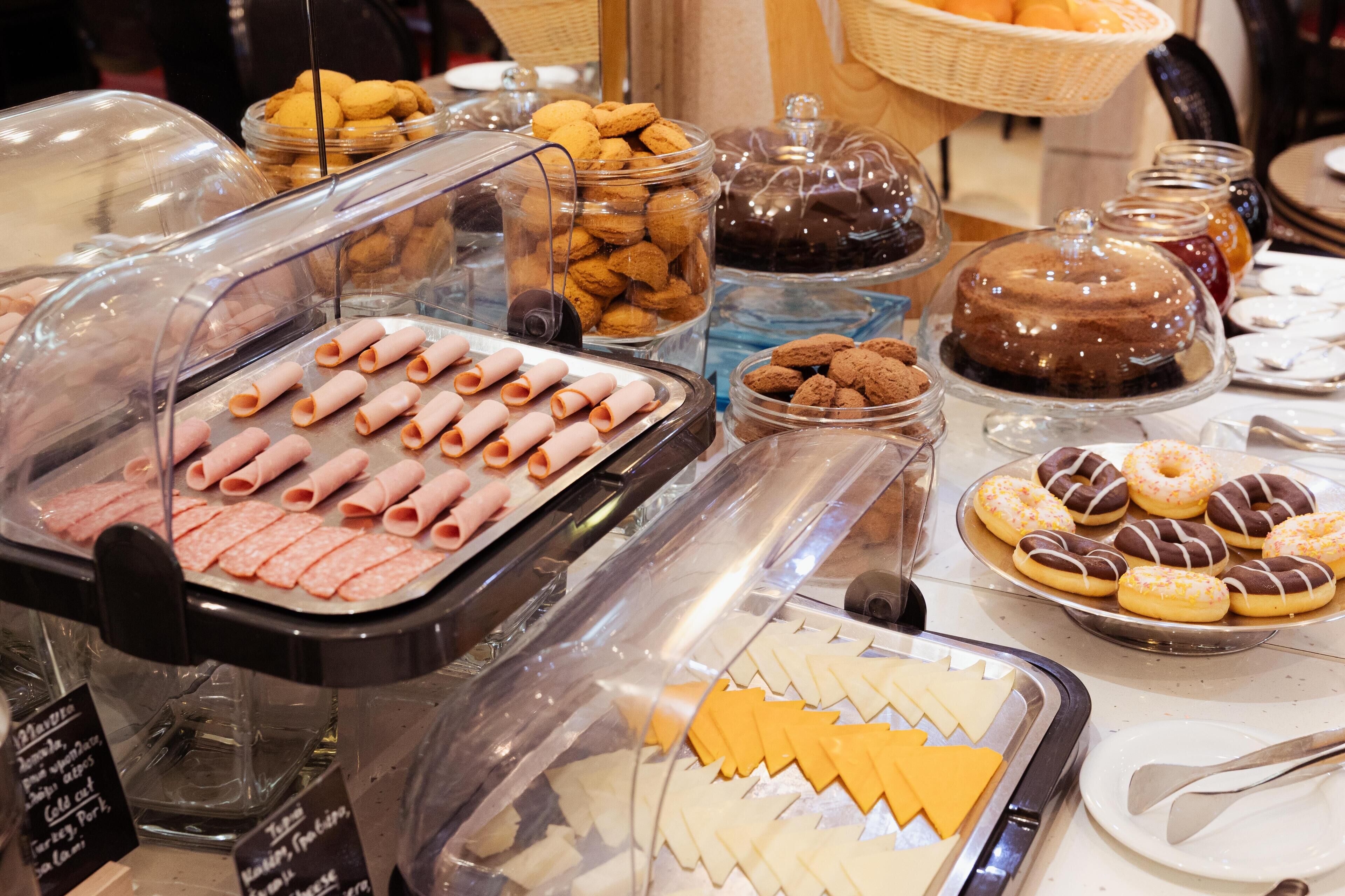 Un buffet proposant une variété de plats, notamment des pâtisseries, des biscuits et du fromage.