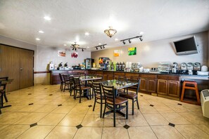 Enjoy meals and beverages in a spacious dining area with a central table and comfortable seating.