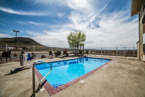 Relax by the pool surrounded by a brick border and lounge chairs.