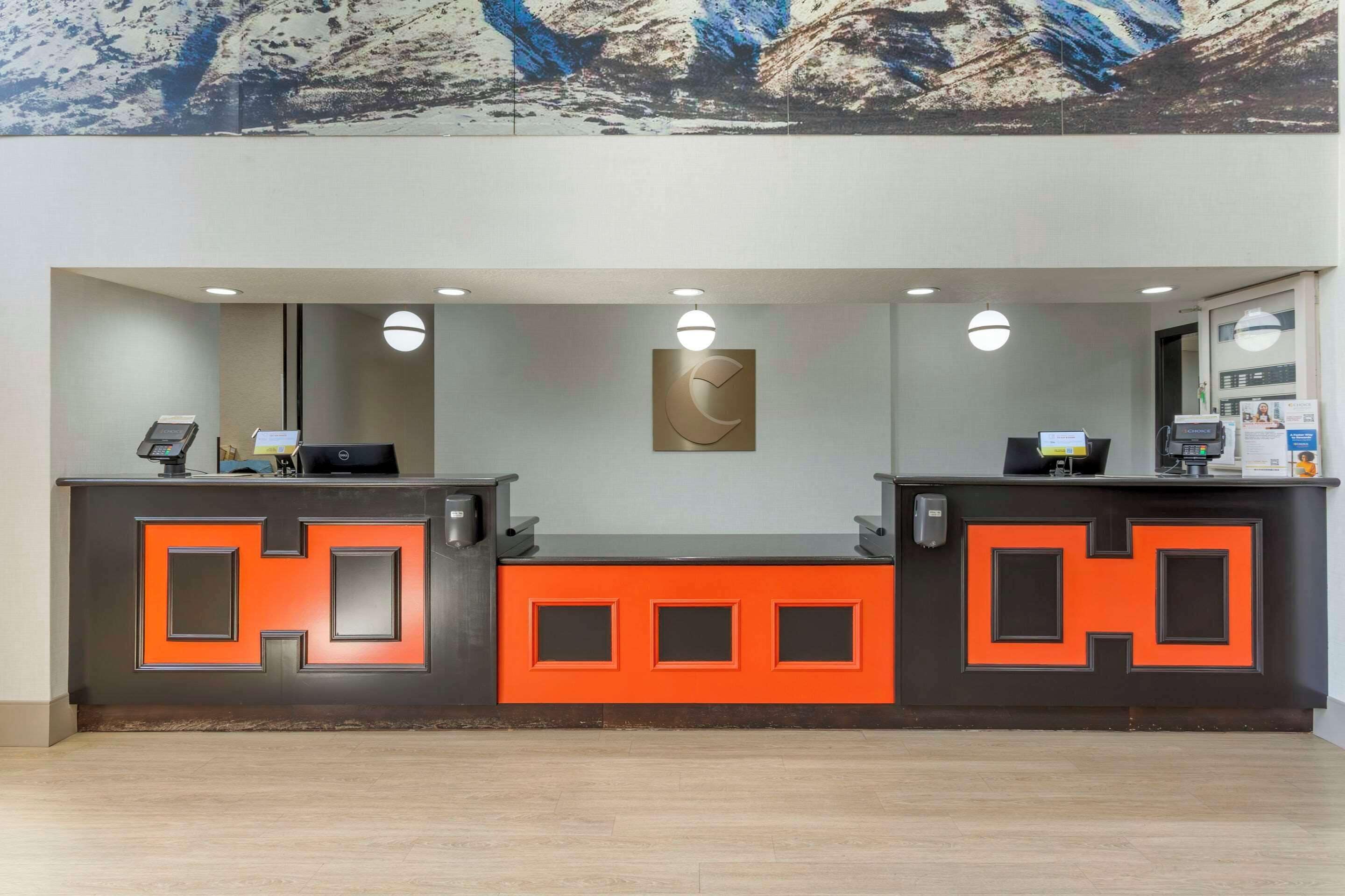 A reception desk with a modern design, featuring a large H-shaped logo and a central artwork.