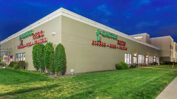 A building with signage for 'Cactus Reds' featuring steaks, ribs, and fruits.