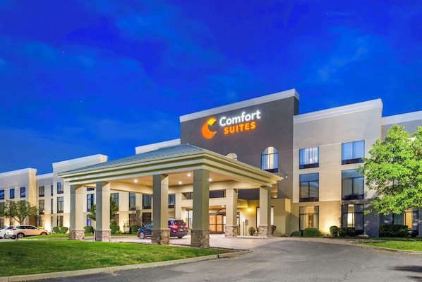 A hotel with a large sign reading "Comfort Suites" and a covered entrance area.