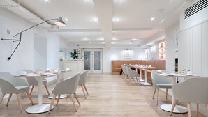 Een moderne eetruimte met witte muren, houten vloeren en modern meubilair.