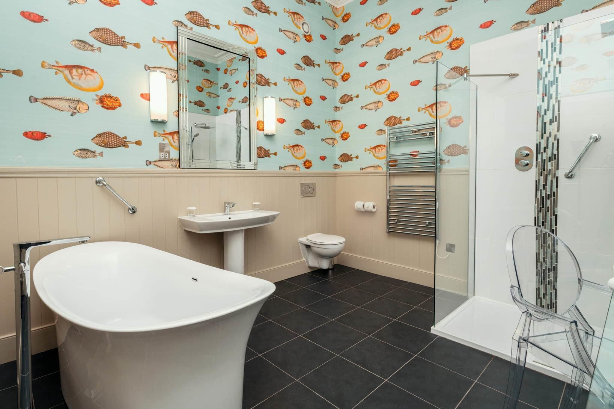 Une salle de bain équipée d’une baignoire, d’un lavabo, de toilettes et d’une douche à parois en verre.