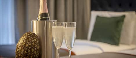 A bottle of champagne, two glasses, and a decorative item on a table in a hotel room.