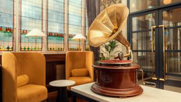 Un gramophone est posé sur une table dans une pièce qui contient deux chaises et une petite table.