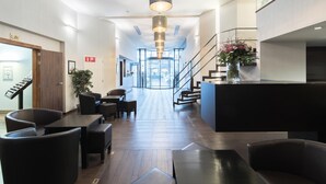 A modern hotel lobby with a reception desk, seating area, and a staircase. - Hotel Chambord (Brussels)