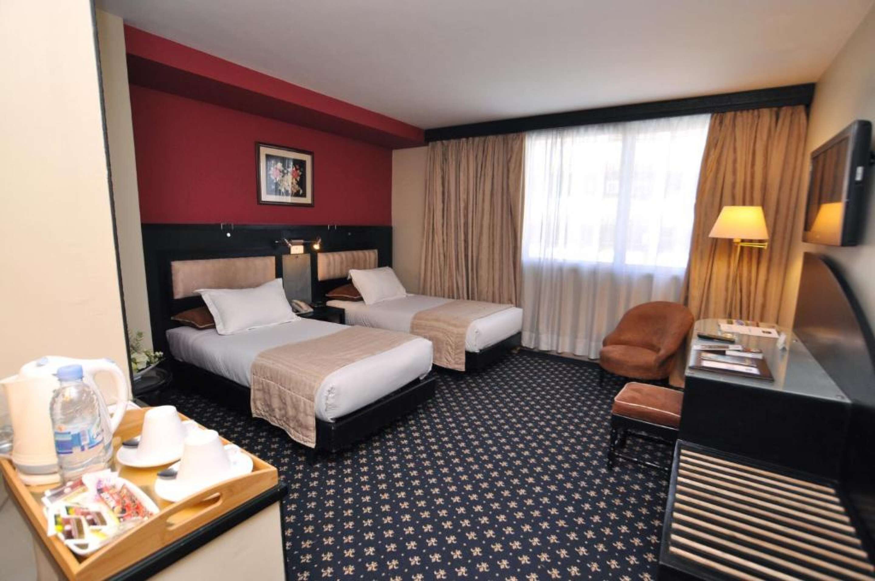 ميني بار وخزنة داخل الغرفة ومساحة عمل للكمبيوتر المحمول وستائر تعتيم