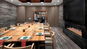 Un vaste espace dédié à la salle à manger, avec une longue table en bois dressée pour le repas, entourée de chaises.