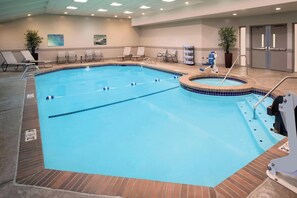 An indoor swimming pool with clear lane dividers, a hot tub, and lounge chairs. - Delta Hotels by Marriott Seattle Everett (Everett)