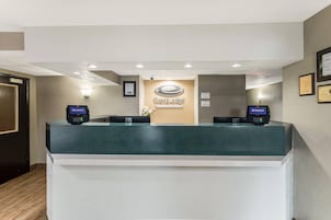 A reception desk with a green counter, two payment terminals, and a wall-mounted sign that reads 'EconomoLodge'.