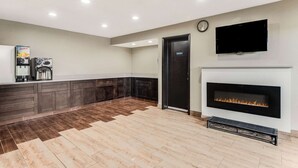 Una cocina moderna con una estación de café integrada, chimenea y televisor de pantalla plana montado en la pared.
