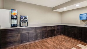 Una cocina moderna con armarios de madera oscura, una encimera blanca y un dispensador de jugo.