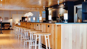 A bar area with wooden bar stools, a counter, and a hanging light fixture. - Laurel Lake Placid (Lake Placid)