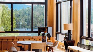 A cozy room with a fireplace, large windows, and a view of a lake. - Laurel Lake Placid (Lake Placid)