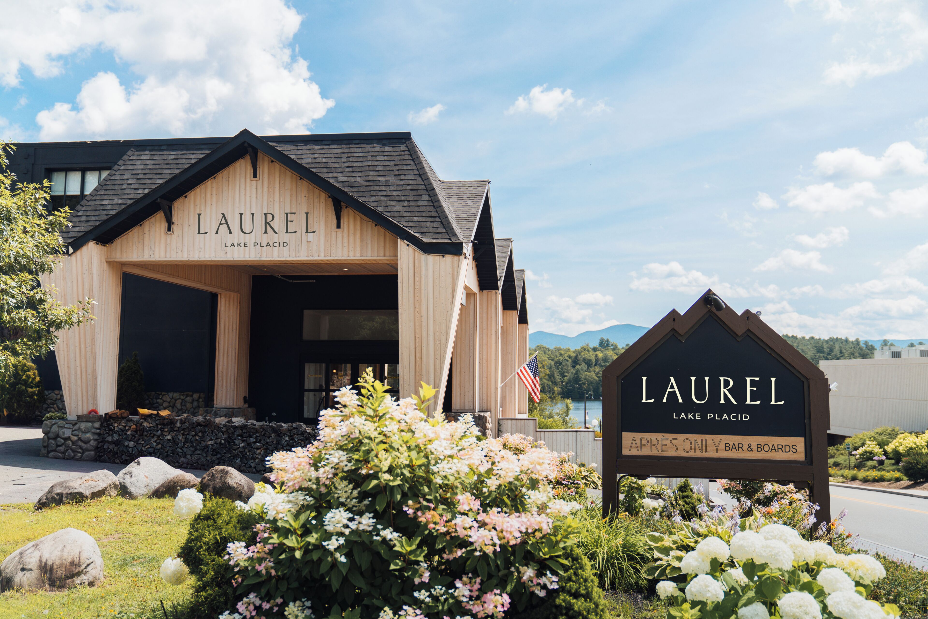 Puinen rakennus, jossa on kyltti, jossa lukee: ”LAUREL LAKE PLACID” ja ”APRES ONLY BAR & BOARDS”.