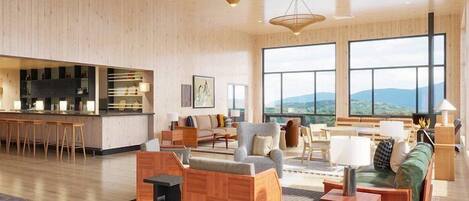 Un espacio habitable espacioso con piso de madera, una zona de bar y ventanas amplias que ofrecen vistas al exterior.