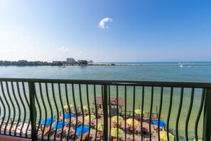 Une vue sur le front de mer avec un espace repas comprenant des sièges et des parasols à l’extérieur.