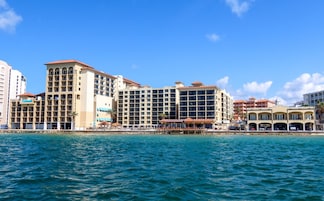 A coastal hotel with multiple floors, balconies, and a beachside location.