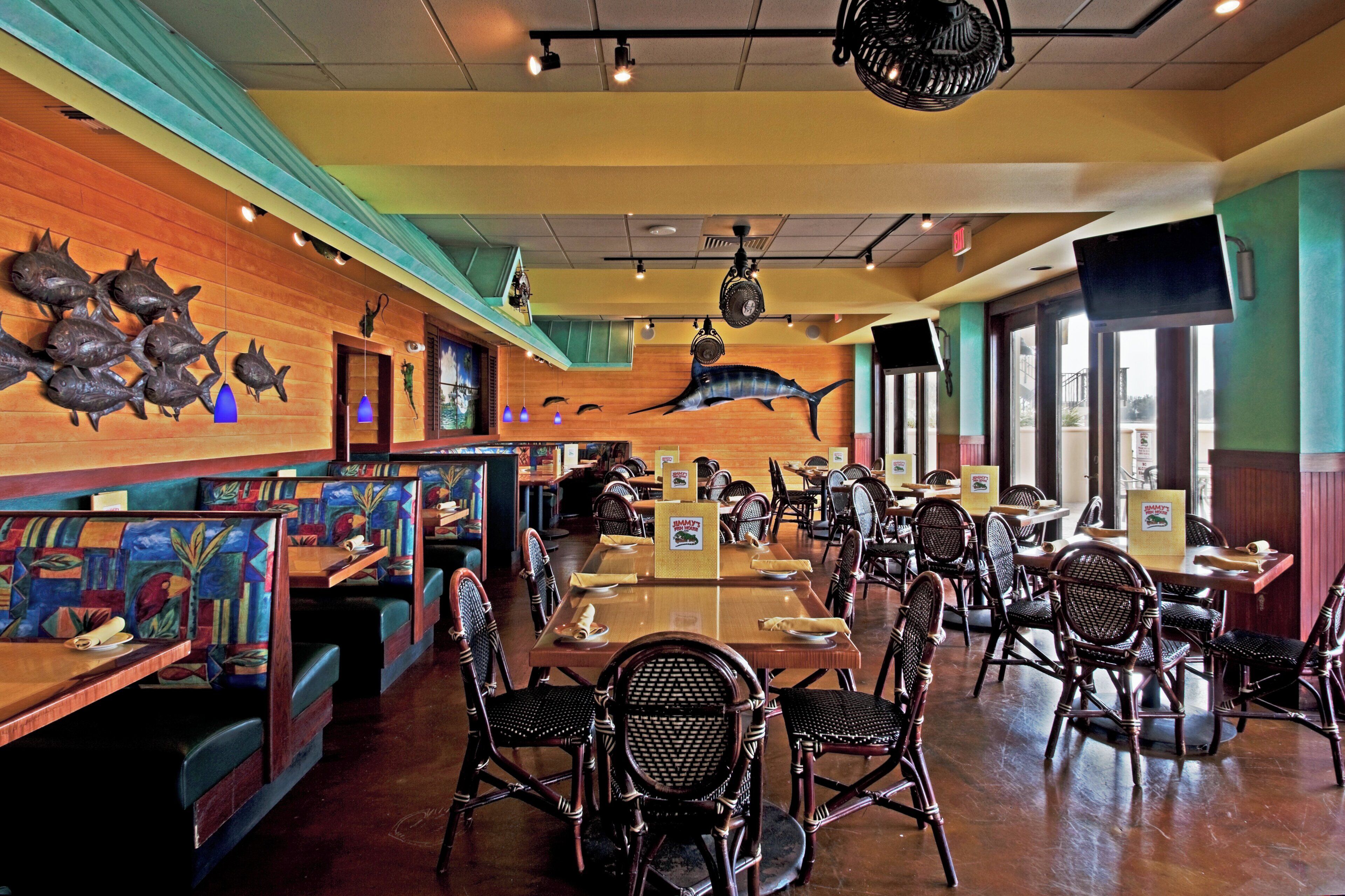 Un interior de restaurante con cabinas, mesas y sillas.