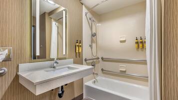 A modern bathroom with a sink, mirror, shower, and bathtub.