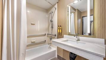 A modern bathroom with a bathtub, a sink, and a mirror.