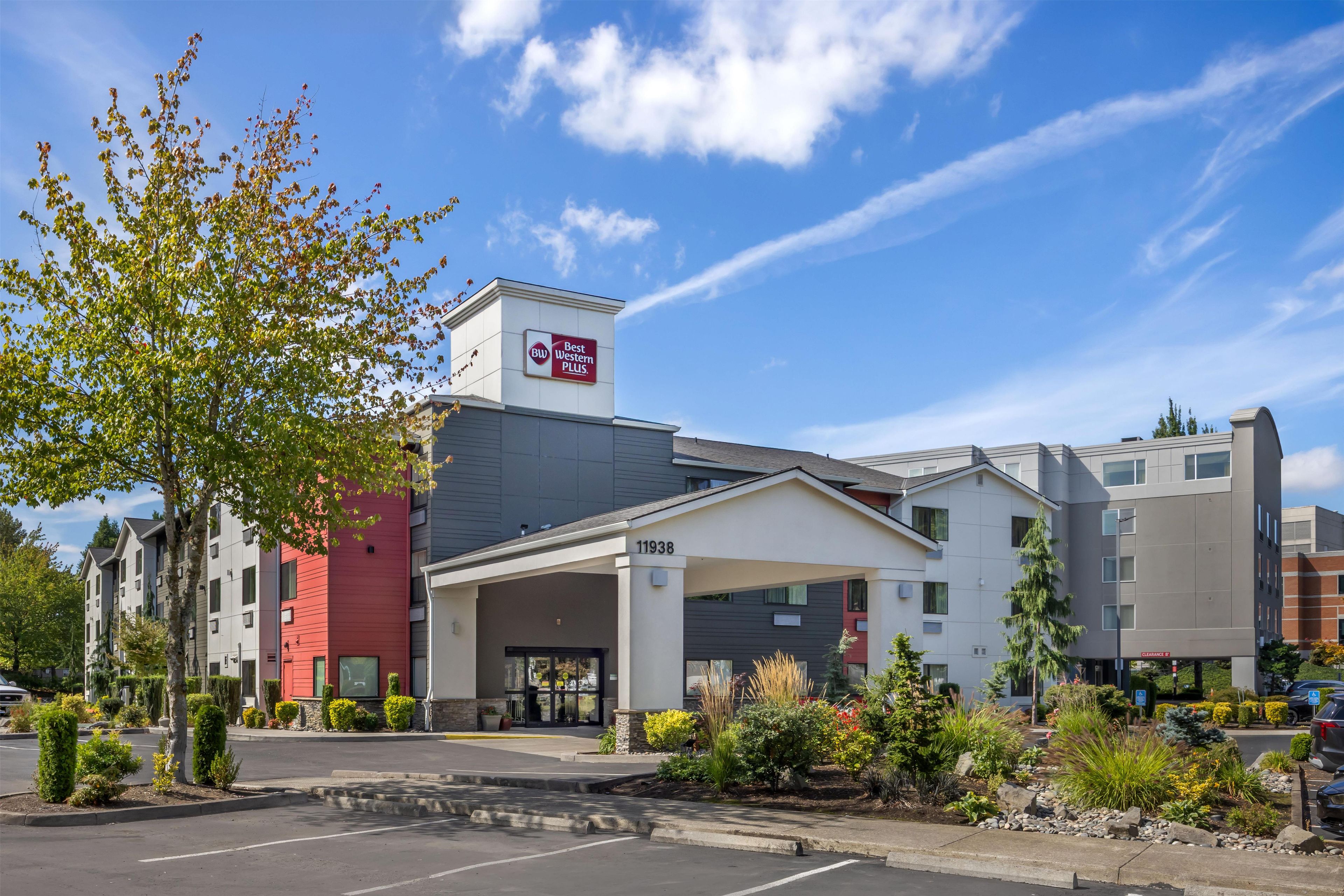 Un hôtel au design moderne, avec une enseigne Best Western PLUS bien visible, une entrée abritée et un parking avec un ciel dégagé en arrière-plan.