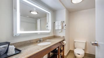 A bathroom with a sink, mirror, and toilet.